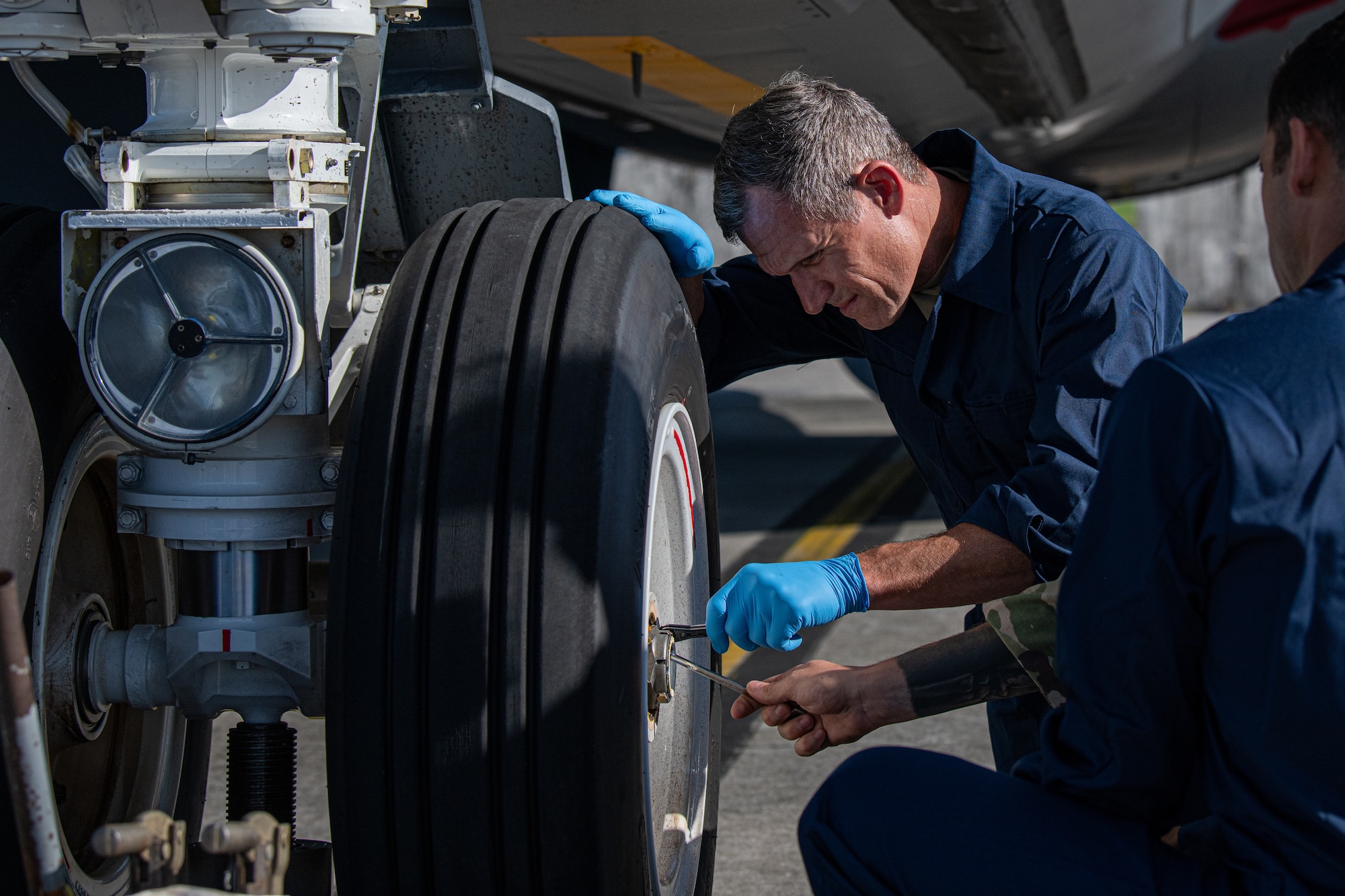 U.S. Air Force Brig. Gen. John Gallemore, 18th Wing commander, conducts a water intrusion check on the nose landing gear of a KC-135 Stratotanker