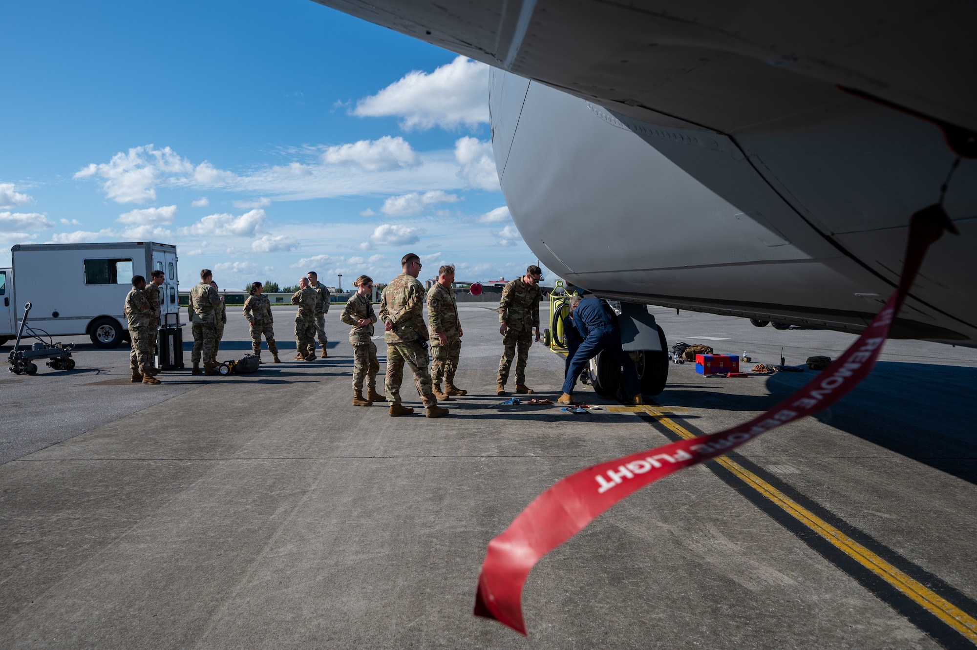 909th Aircraft Maintenance Unit leadership observes 18th Wing leadership removing a tire from a KC-135 Stratotanker