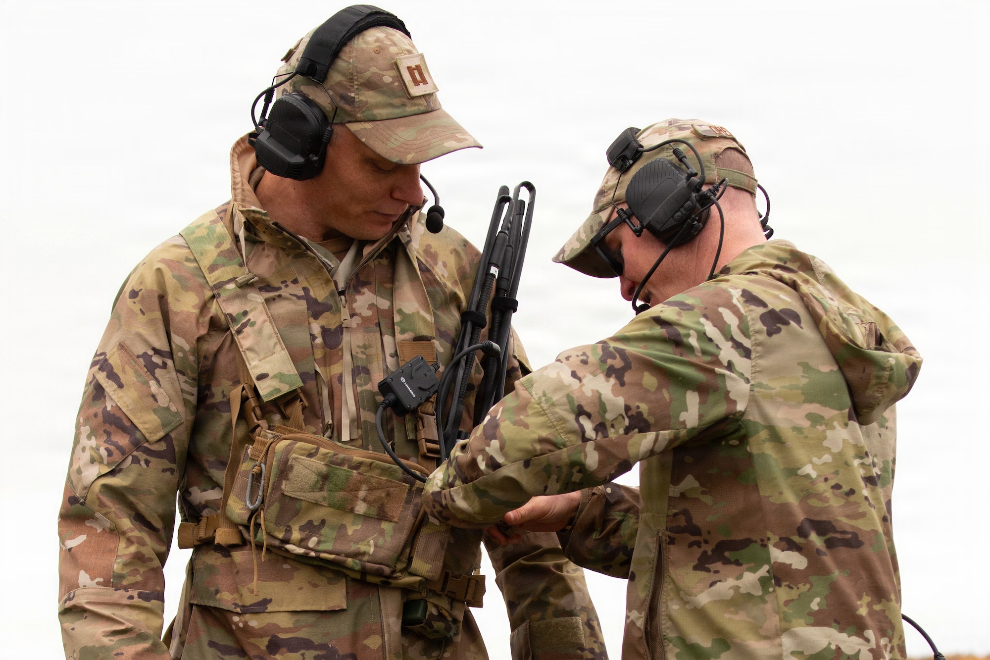 Tech. Sgt. Dylan Drenner, a landing zone safety officer (LZSO) assigned to the 3rd Operations Support Squadron, secures communication equipment on U.S. Air Force Capt. Benjamin Graham, a 3 OSS flight commander for a landing exercise on Joint Base Elmendorf-Richardson, Alaska, Sept. 26, 2025. LZSOs are required to monitor communication devices to ensure all personnel on the flightline can effectively communicate, clear the flightline and safely land aircraft. (U.S. Air Force photo by Airman Keola Vischi)