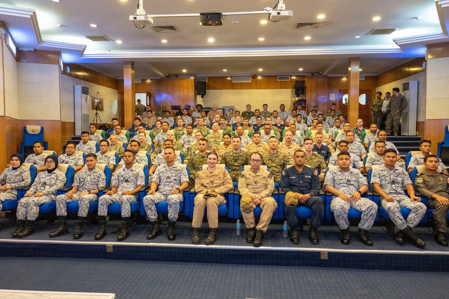 U.S. service members and Malaysian Armed Forces members take a group photo during the opening ceremony of Cooperation Afloat Readiness and Training (CARAT) Malaysia 2025, at Lumut Naval Base, in Lumut, Malaysia, Dec. 4, 2025. This year marks the 31st iteration of CARAT, a multinational exercise series designed to enhance U.S. and partner navies' abilities to operate together in response to traditional and nontraditional maritime security challenges in the Indo-Pacific region. (U.S. Navy photo by Mass Communication Specialist 2nd Class Anthony Robledo)