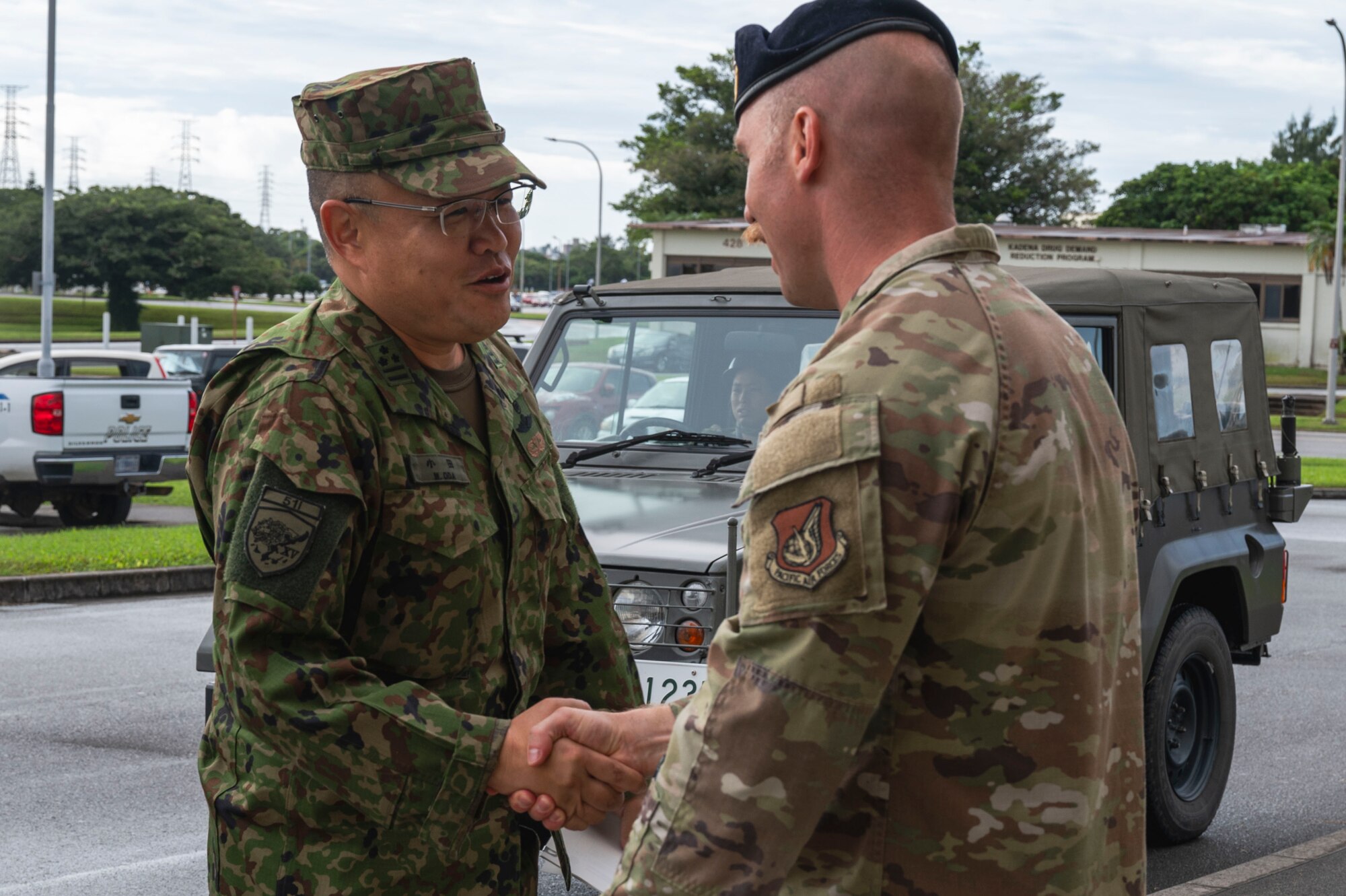 U.S. Air Force Lt. Col. Bradley Robinson, 18th Security Forces commander, greets Japan Ground Self-Defense Force Col. Masahiro Oda, 51st Infantry Regiment commander, left, at Kadena Air Base, Japan, Oct. 25, 2025.