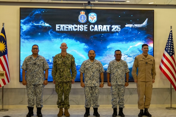 U.S. Navy Capt. Matt B. Cox, center left, deputy commodore, Destroyer Squadron (DESRON) 7, and U.S. Navy Cmdr. Andrew Recame, right, commanding officer of the Independence-variant littoral combat ship USS Cincinnati (LCS 20), pose for a group photo with Royal Malaysian Navy (RMN) leadership following the commencement of Cooperation Afloat Readiness and Training (CARAT) Malaysia 2025 at Lumut Naval Base, Lumut, Malaysia, Dec. 4, 2025. This year marks the 31st iteration of CARAT, a multinational exercise series designed to enhance U.S. and partner navies' abilities to operate together in response to traditional and non-traditional maritime security challenges in the Indo-Pacific region. (U.S. Navy photo by Mass Communication Specialist 2nd Class Anthony Robledo)