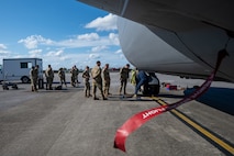 909th Aircraft Maintenance Unit leadership observes 18th Wing leadership removing a tire from a KC-135 Stratotanker
