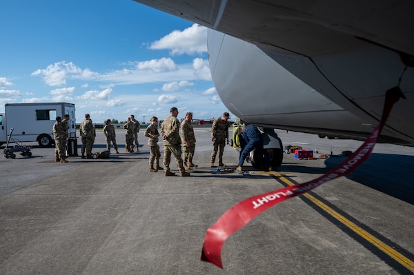 909th Aircraft Maintenance Unit leadership observes 18th Wing leadership removing a tire from a KC-135 Stratotanker