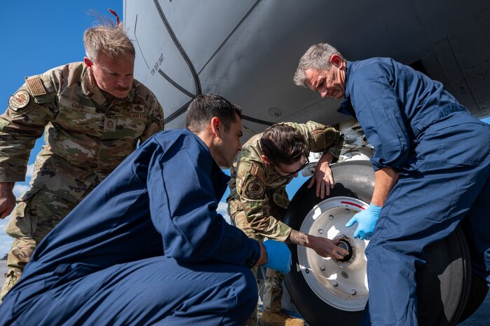 U.S. Air Force Staff Sgt. Alex Farwell, center, 909th Aircraft Maintenance Unit KC-135 Stratotanker crew chief, and the 18th Wing leadership team conduct a water intrusion check on the nose landing gear of a KC-135