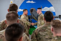 U.S. Air Force Chief Master Sgt. William Cupp, left, 18th Wing command chief presents a coin to Airman 1st Class Nicholas Pueschel, 909th Aircraft Maintenance Unit KC-135 Stratotanker crew chief