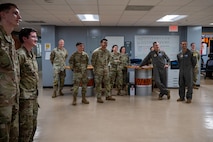 Airmen from the 909th Aircraft Maintenance Unit and 18th Wing leadership observe an airman getting coined