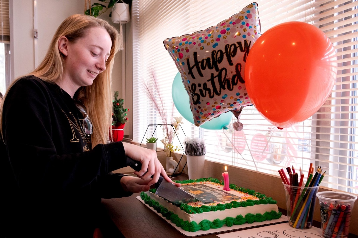 Kelsey McShan, Touch & Go lead barista, cuts a cake during the one-year anniversary celebration of the shop’s opening at Misawa Air Base, Japan, Dec. 2, 2025. The celebration’s cake and decorations highlighted the role of quality-of-life spaces in supporting connections across Misawa Air Base. (U.S. Air Force photo by Airman 1st Class Jessel Fabara)