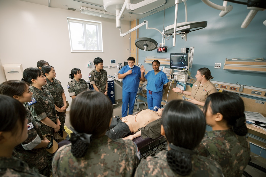Hospitalman Chris Rico, Hospital Corpsman 3rd Class Niesha Parker, and Lt. Kailee Baughman conduct basic life support training for Republic of Korea (ROK) Military Nursing Academy cadets during a clinical skills rotation at U.S. Naval Hospital Guam, Nov. 14, 2025. The instructors demonstrated proper chest compression techniques and emergency response fundamentals as part of the command’s hands-on medical readiness tour. (U.S. Navy photo by Hospital Corpsman 1st Class Clien Lester Guico.)