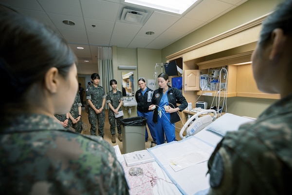 Hospitalman Nalani Cui and Lt. Hayley Wood demonstrate the setup and operation of intravenous infusion pumps for Republic of Korea (ROK) Military Nursing Academy cadets during a clinical skills rotation at U.S. Naval Hospital Guam, Nov. 14, 2025. The hands-on demonstration familiarized cadets with infusion equipment used in inpatient care settings and highlighted key principles of safe medication administration. (U.S. Navy photo by Hospital Corpsman 1st Class Clien Lester Guico.)