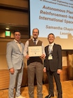 U.S. Naval Research Laboratory (NRL) Senior Scientist for Robotics and Autonomous Systems Glen Henshaw, Ph.D., accepts the Best Paper Award in Orbital Robotics on behalf of the Autonomous Planning In-space Assembly Reinforcement-learning free-flyer (APIARY) team at the 2025 International Conference on Space Robotics (iSpaRo) in Sendai, Japan, on Dec. 3, 2025.