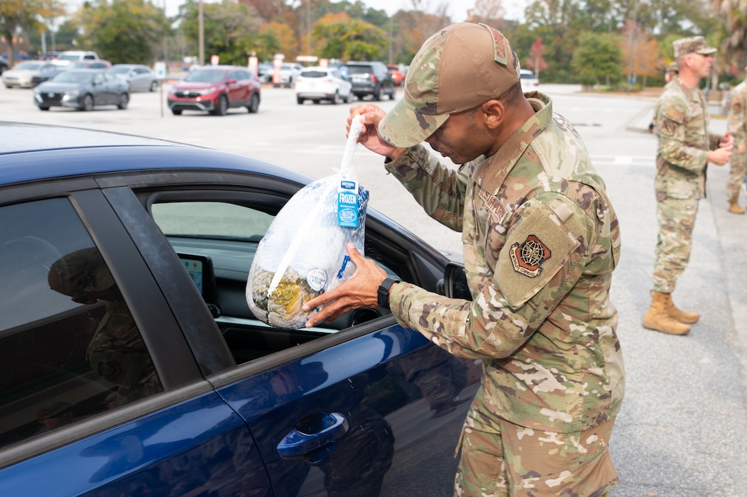 Airman handing turkey to motorist