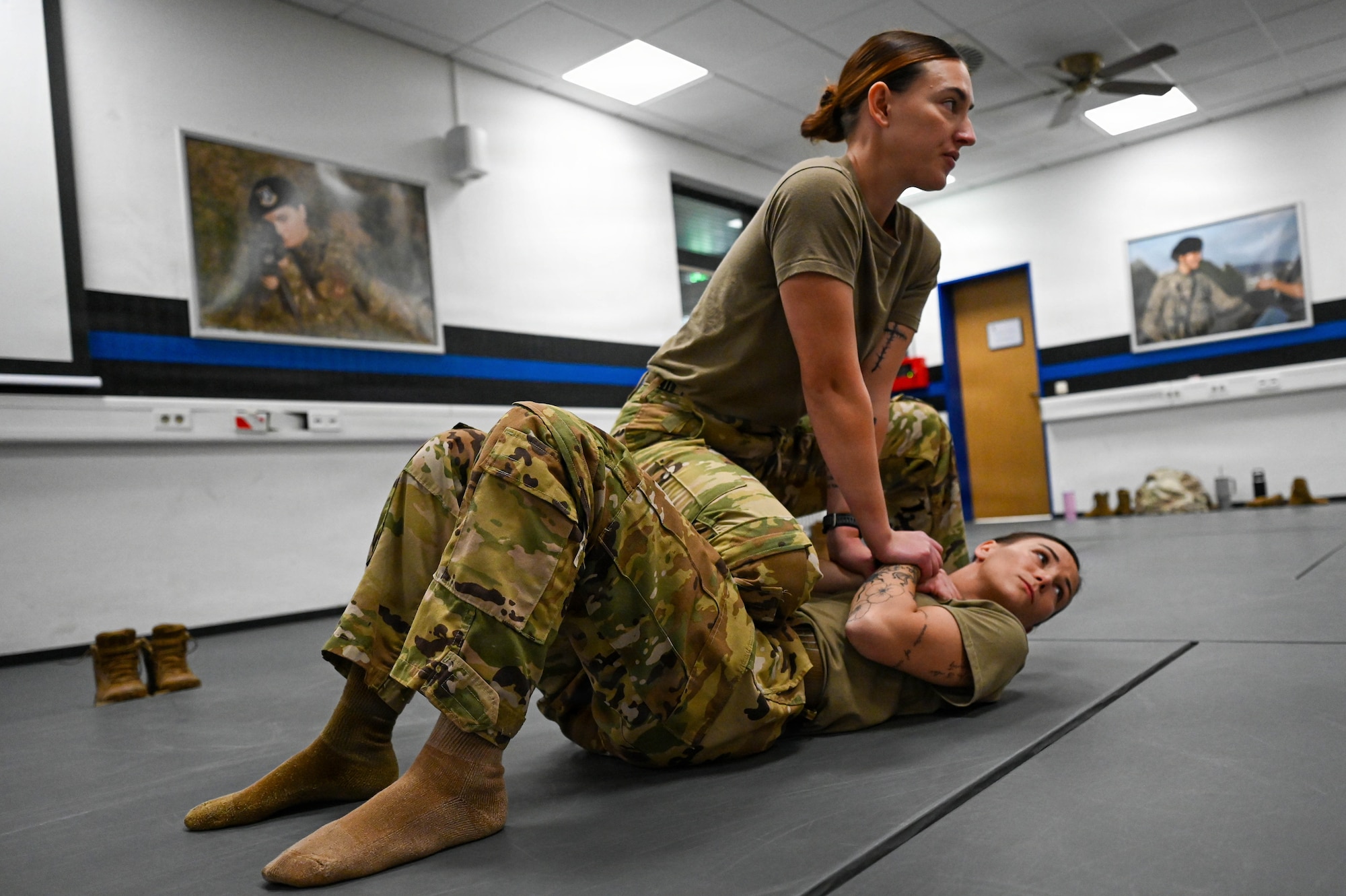 U.S. Air Force Staff Sgt. Victoria Kelly, bottom, and Staff Sgt. Kristen Wurtz, 446th Security Forces Squadron Phoenix Raven team members, teach combative maneuvers to in-processing 86th Security Forces Airmen at Ramstein Air Base, Germany, Nov. 24, 2025.