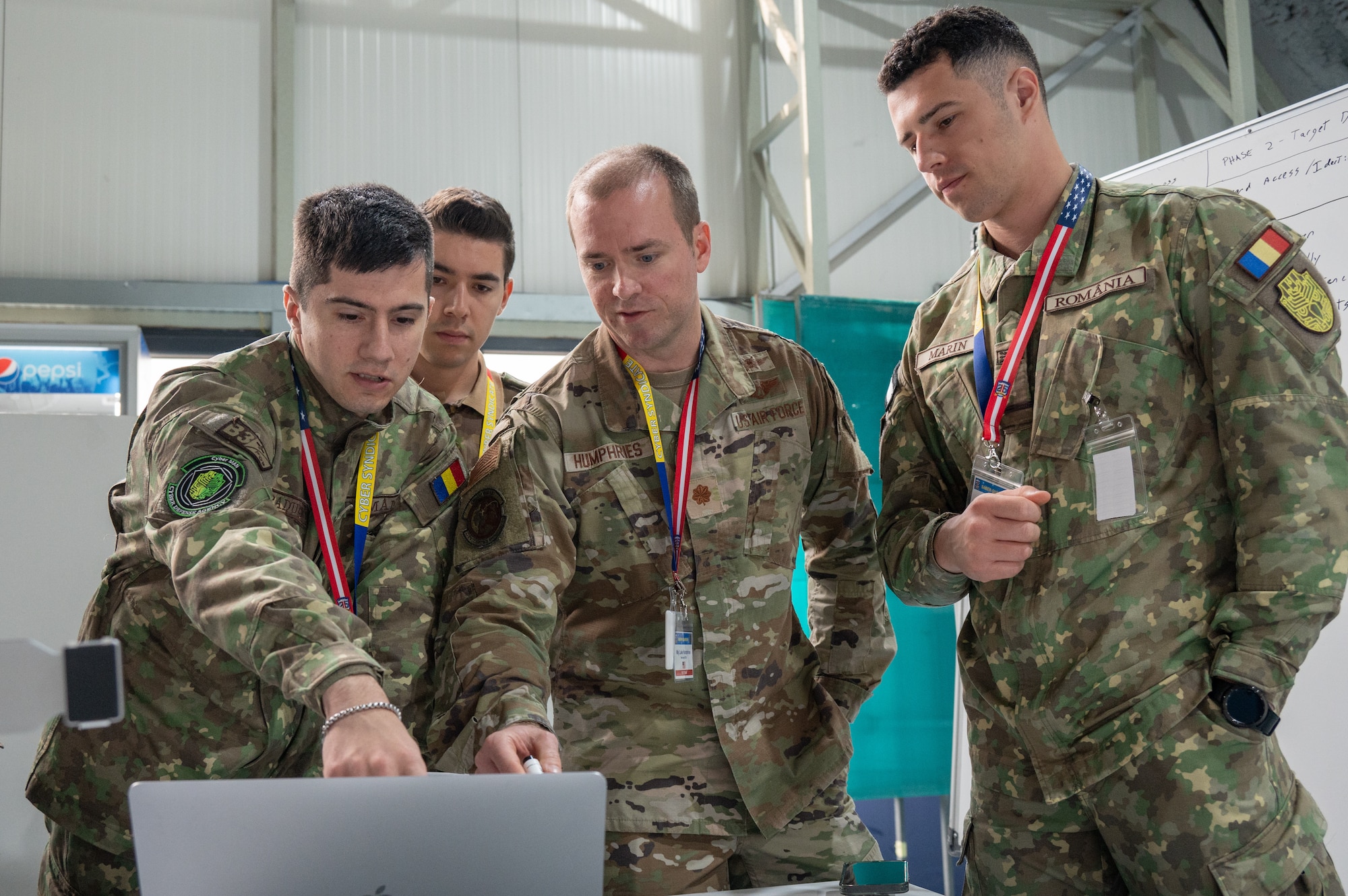 Maryland Air National Guard Maj. Luke Humphries, a cyber operator assigned to the 276th Cyberspace Operations Squadron, works together with cyber operators from the Romanian Cyber Command to conduct red team operations during the Saber Guardian 25 cyber exercise as part of DEFENDER 25, June 12, 2025, in Bucharest, Romania. Airmen from the Maryland Air National Guard and NATO counterparts from the Romanian Cyber Command who participated in red team cyber operations emulated adversarial cyber attacks in a simulated network and worked to identify weaknesses and vulnerabilities.



Demonstrating global deterrence and the U.S. Army’s ability to rapidly deploy U.S.-based combat power in Europe and the Arctic region alongside Allies and partners, DEFENDER 25 brings U.S. troops together with forces from 29 Allied and partner nations to build readiness through large-scale combat training from May 11 to June 24, 2025. DEFENDER 25 increases the lethality of the NATO alliance through large-scale tactical training maneuvers and long-range fires, build unit readiness in a complex joint, multinational environment, and leverages host nation capabilities to increase the U.S. Army’s operational reach. During three large-scale combat training exercises — Swift Response, Immediate Response, and Saber Guardian — Ally and partner forces integrate and expand multi-domain operations capability, demonstrating combined command and control structures and readiness to respond to crisis and conflict. (U.S. Air National Guard photo by Staff Sgt. Laura Virtue)(This photo has been altered for security purposes by blurring out access badges.)