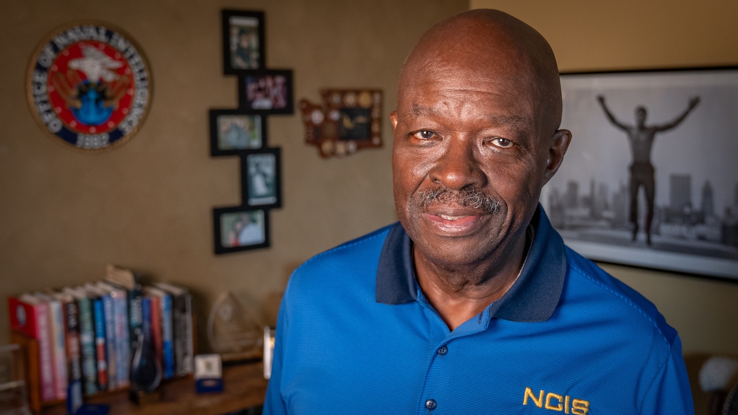 Retired NCIS Special Agent Leon Carroll stands in his office amongst memorabilia collected during his time with the agency.