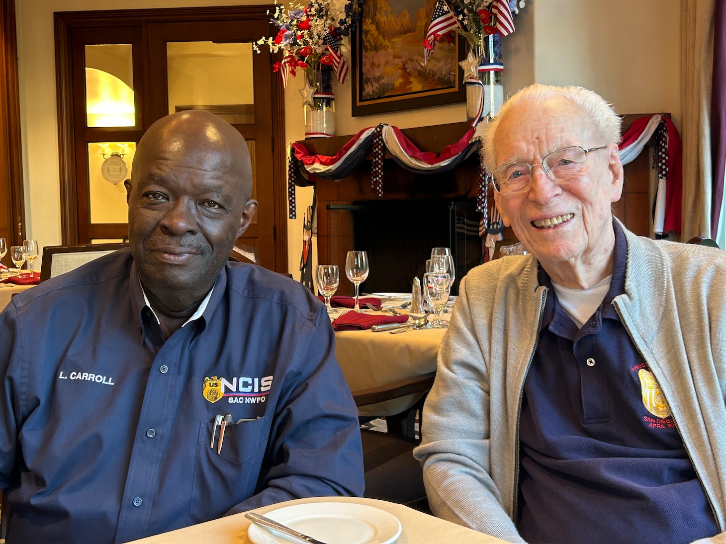 Retired Special Agents Leon Carroll and Roy Mosteller sit together at a table
