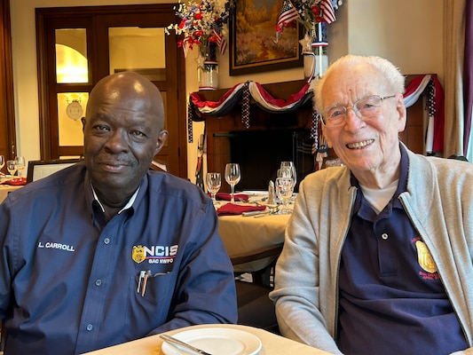 Retired Special Agents Leon Carroll and Roy Mosteller sit together at a table