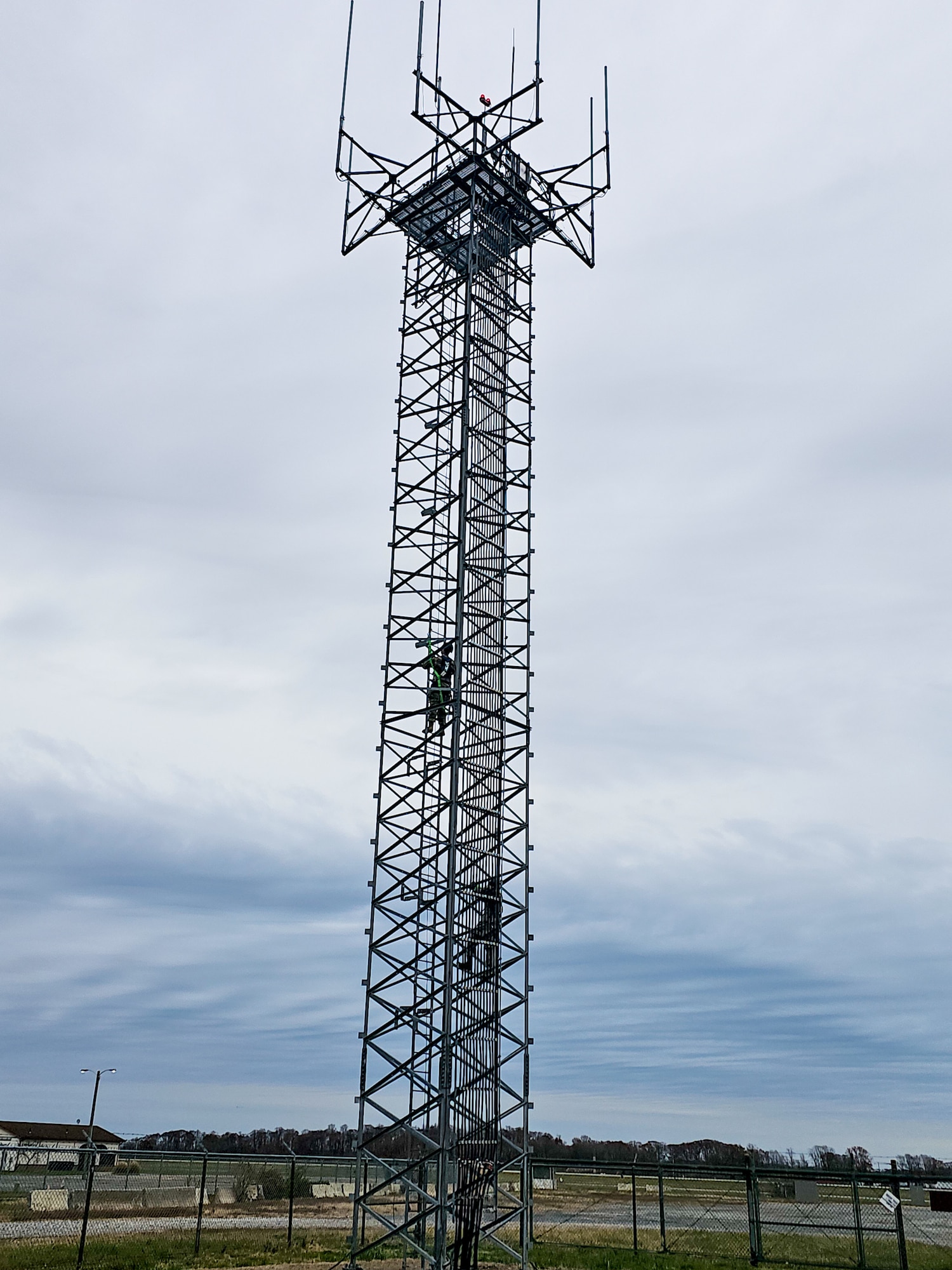 U.S. Air Force Col. Jamil Musa, 436th Airlift Wing commander, and Chief Master Sgt. Gary West, 436th AW interim command chief, climb a radio tower during a Dover Duties tour at Dover Air Force Base, Delaware, Nov. 25, 2025. The tower was one of three radar airfield weather systems facilities visited by the command team during the tour. (U.S. Air Force photo by Mauricio Campino)