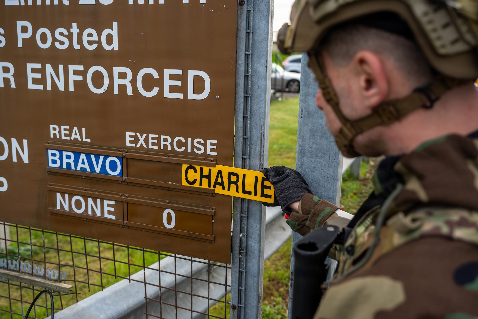 U.S. Air Force Staff Sgt. Ian Eckert, 422nd Security Forces Squadron flight sergeant, changes a FPCON sign