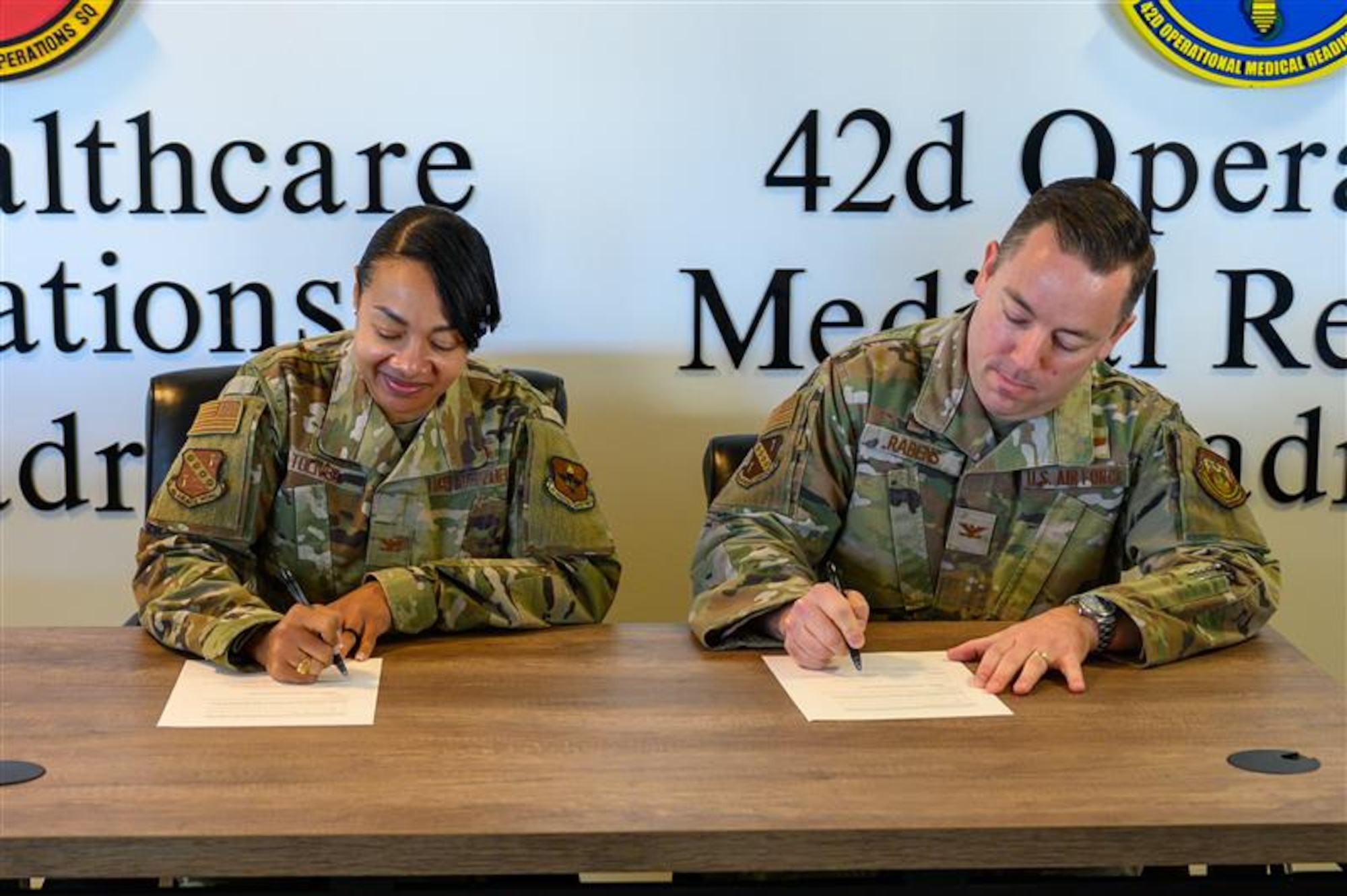 U.S. Air Force Col. Shamekia Toliver, 42d Air Base Wing commander and U.S. Air Force Col. Clayton Rabens, Maxwell Medical Group commander, sign a base support agreement strengthening cooperation between the 42d ABW and newly established Maxwell Medical Group under the 359th Medical Wing. A support agreement ensures clear responsibilities, reliable services and uninterrupted mission support between the installation and its newest tenant unit. (U.S. Air Force photo by Senior Airman Evan Lichtenhan)