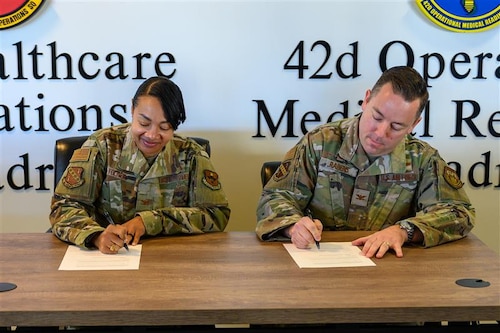 U.S. Air Force Col. Shamekia Toliver, 42d Air Base Wing commander and U.S. Air Force Col. Clayton Rabens, Maxwell Medical Group commander, sign a base support agreement strengthening cooperation between the 42d ABW and newly established Maxwell Medical Group under the 359th Medical Wing. A support agreement ensures clear responsibilities, reliable services and uninterrupted mission support between the installation and its newest tenant unit. (U.S. Air Force photo by Senior Airman Evan Lichtenhan)