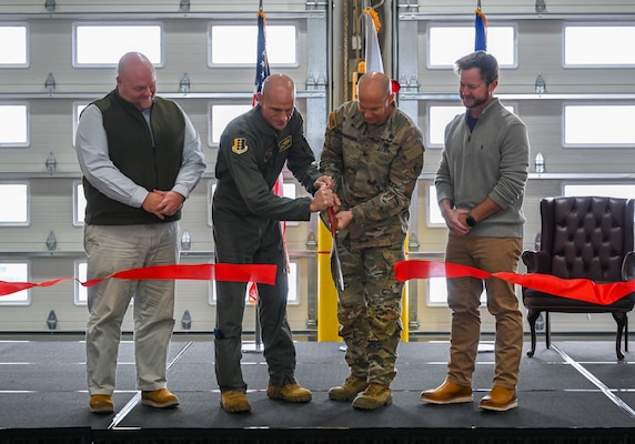 U.S. Air Force Col. Erick Lord, (left), 28th Bomb Wing commander, and U.S. Army Col. Robert Newbauer cut a ribbon during a ribbon cutting ceremony at Ellsworth Air Force Base, S.D., Dec. 3, 2025. They were joined by Randy Scott, (far left), vice president of RC Construction, and Jay Warren, project manager of RC Construction, who were contributing members of the runway project. (U.S. Air Force photo by Airman 1st Class Alec Carlberg)