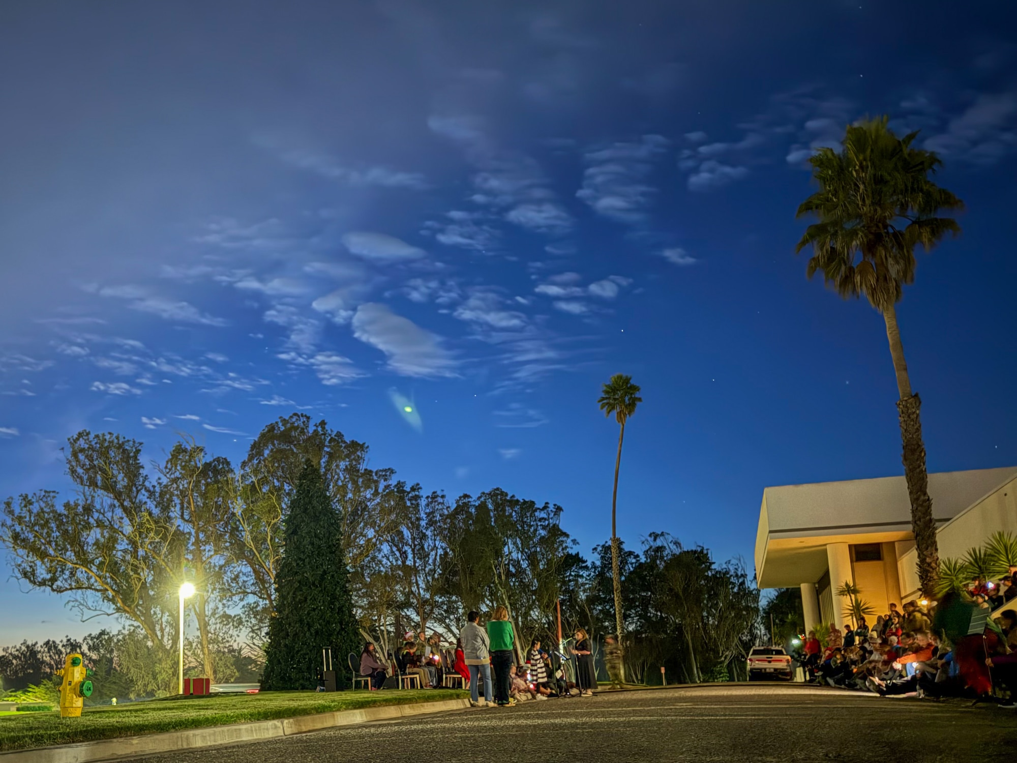 Groups of Vandenberg families sit on the curb outside the Pacific Coast Club.