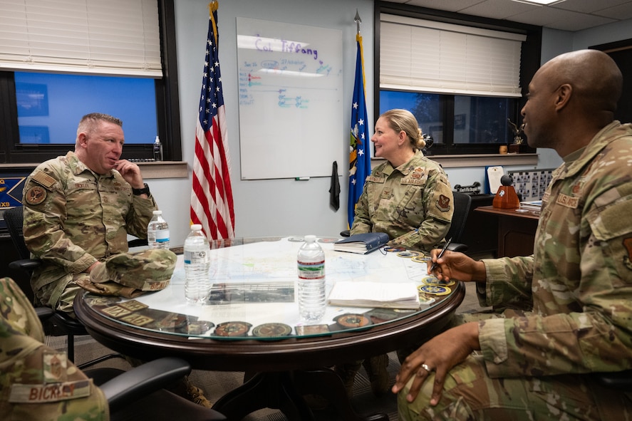 Chief Master Sgt. Chad W. Bickley sits at a table with Col. Tiffany L. Arnold and U.S. Air Force Chief Master Sgt. Anthony Anderson.