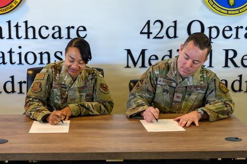 U.S. Air Force Col. Shamekia Toliver, 42d Air Base Wing commander and U.S. Air Force Col. Clayton Rabens, Maxwell Medical Group commander, sign a base support agreement strengthening cooperation between the 42d ABW and newly established Maxwell Medical Group under the 359th Medical Wing. A support agreement ensures clear responsibilities, reliable services and uninterrupted mission support between the installation and its newest tenant unit. (U.S. Air Force photo by Senior Airman Evan Lichtenhan)