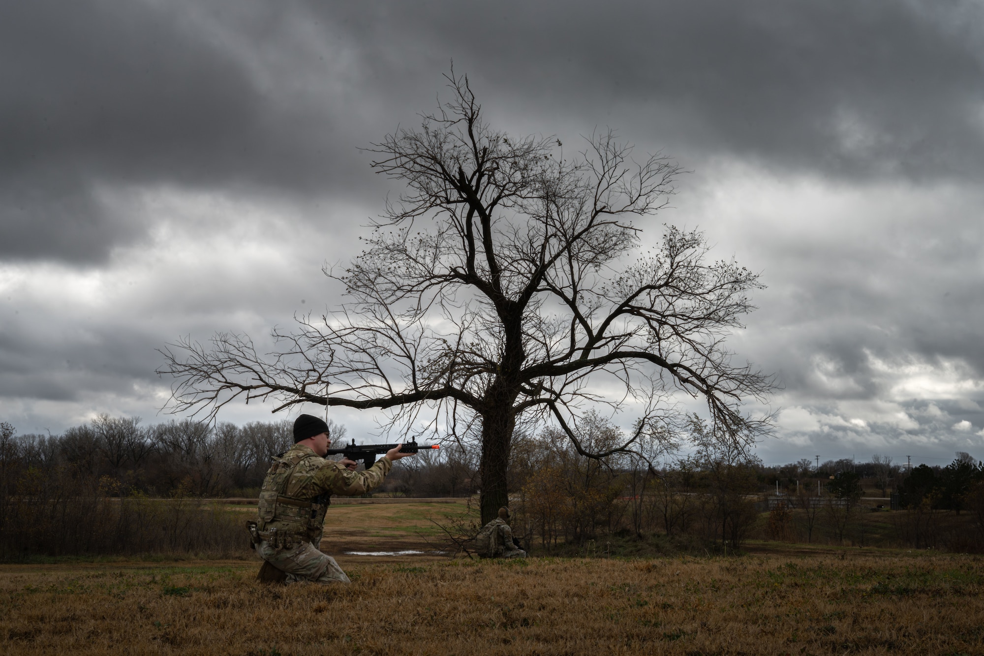 A 22nd Security Forces Squadron Airman aims a trainer weapon during a readiness exercise at McConnell Air Force Base, Kansas, Nov. 21, 2025. These defenders hit Mount Village, a simulated urban location, for a week of realistic scenarios including casualty care training, team movement, combatives, and close quarters battles. (U.S. Air Force photo by Senior Airman Paula Arce)