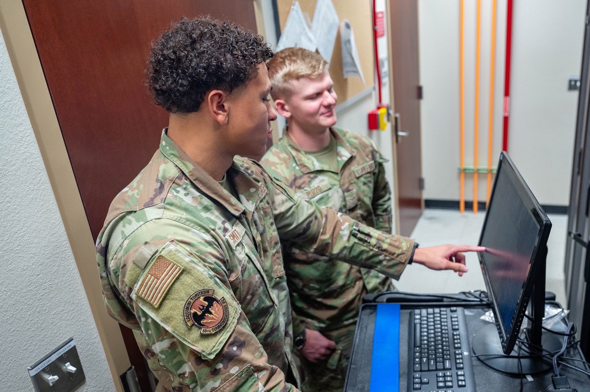 U.S. Air Force Airman 1st Class Devyn Smith (left), and Airman 1st Class Dominic Puzzo (right), both 56th Communications Squadron network systems operation technicians, work together to maintain a server, Oct. 1, 2025, at Luke Air Force Base, Arizona.