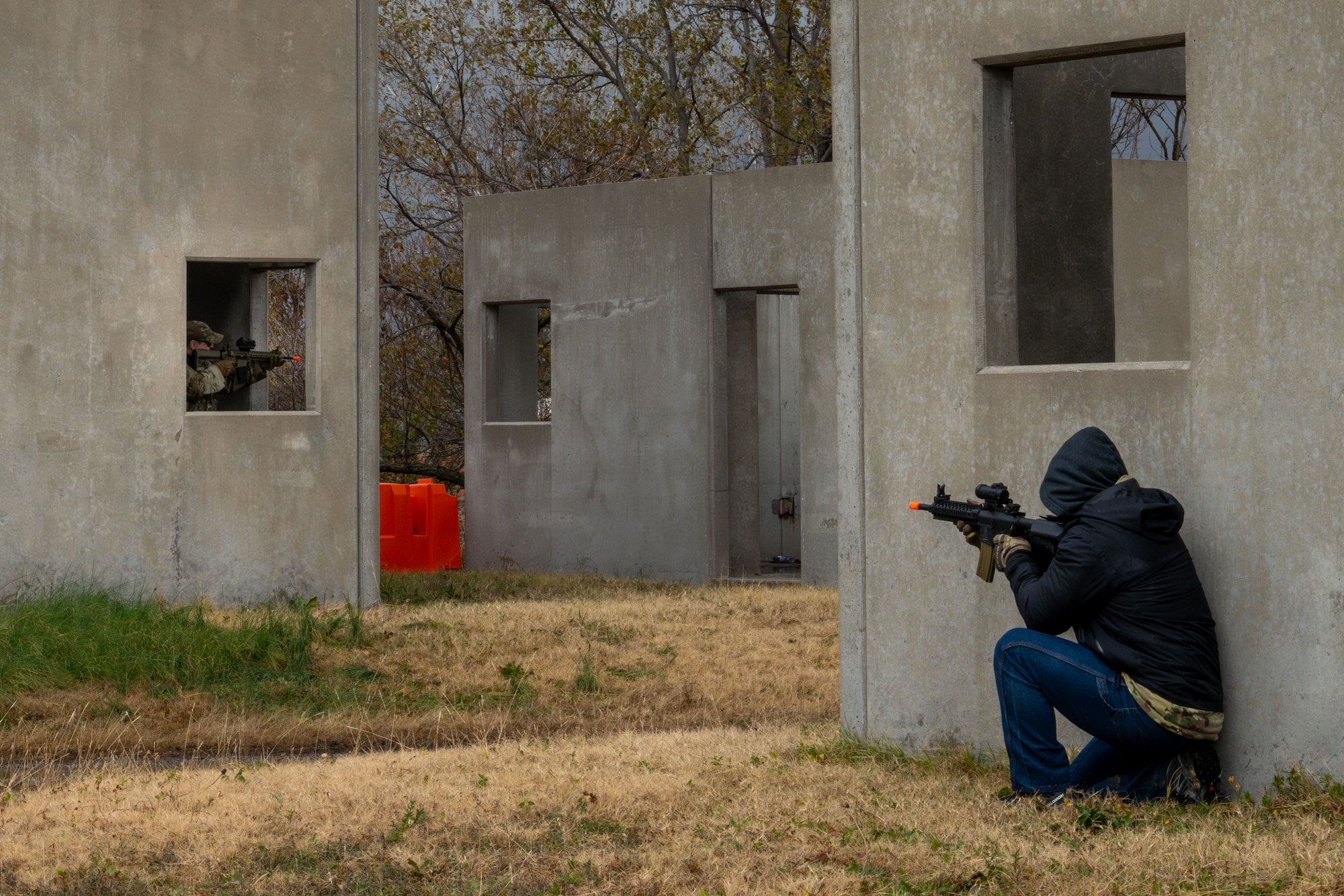 An opposing force aims a trainer weapon at a 22nd Security Forces Squadron member during a Mount Village readiness exercise at McConnell Air Force Base, Kansas, Nov. 21, 2025. Fellow Airmen acting as opposing forces attempted to take control of Mount Village from defenders during a simulated close quarters battle scenario. (U.S. Air Force photo by Senior Airman Paula Arce)