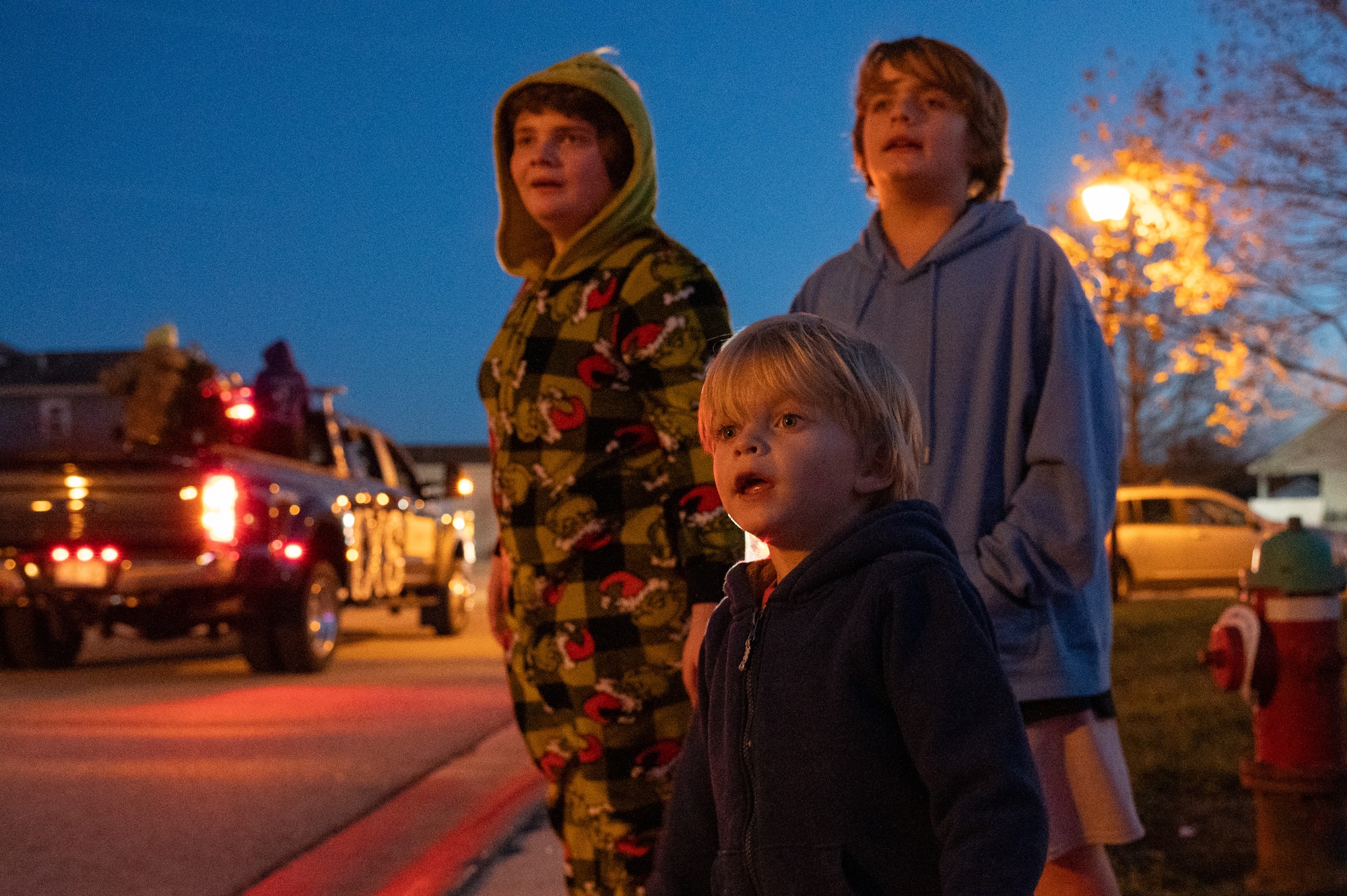 Team Dover residents of Hunt Housing watch the annual holiday parade at Dover Air Force Base, Delaware, Dec. 1, 2025. The annual parade travels through the housing area where many Team Dover families live. (U.S. Air Force photo by Mauricio Campino)