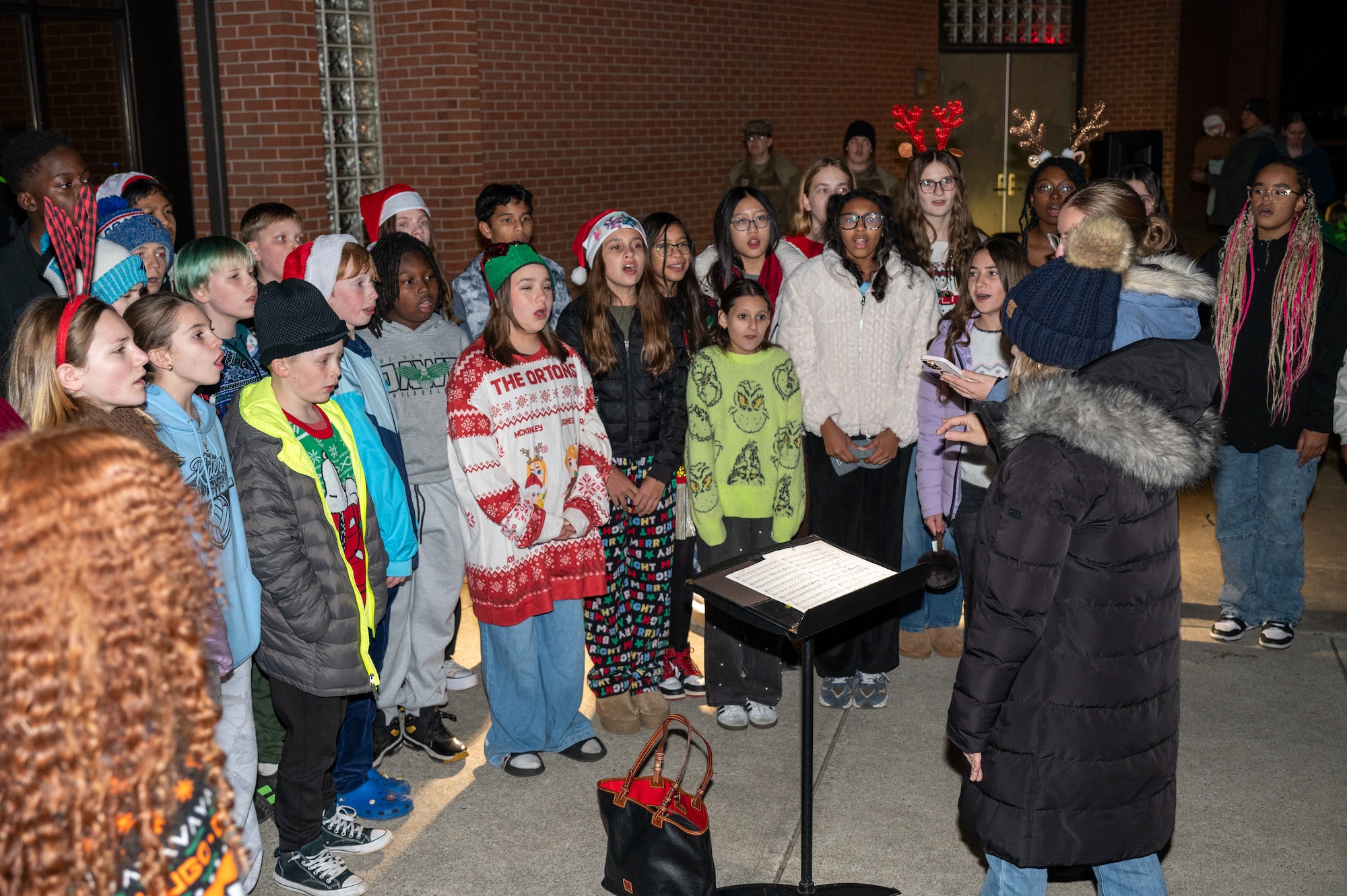 The Dover Air Base Middle School choir sings Christmas carols at the conclusion of the annual holiday parade at Dover Air Force Base, Delaware, Dec. 1, 2025. The parade was followed by a tree lighting celebration. (U.S. Air Force photo by Mauricio Campino)