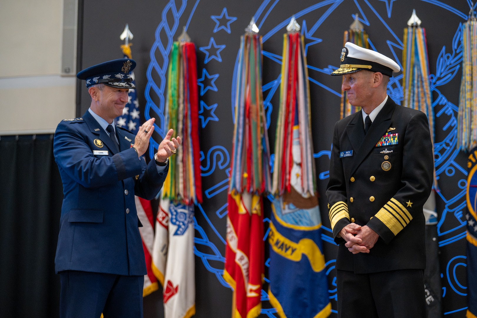 Chairman of the Joint Chiefs of Staff Gen. Dan Caine congratulates Adm. Rich Correll on his assumption of command of U.S. Strategic Command