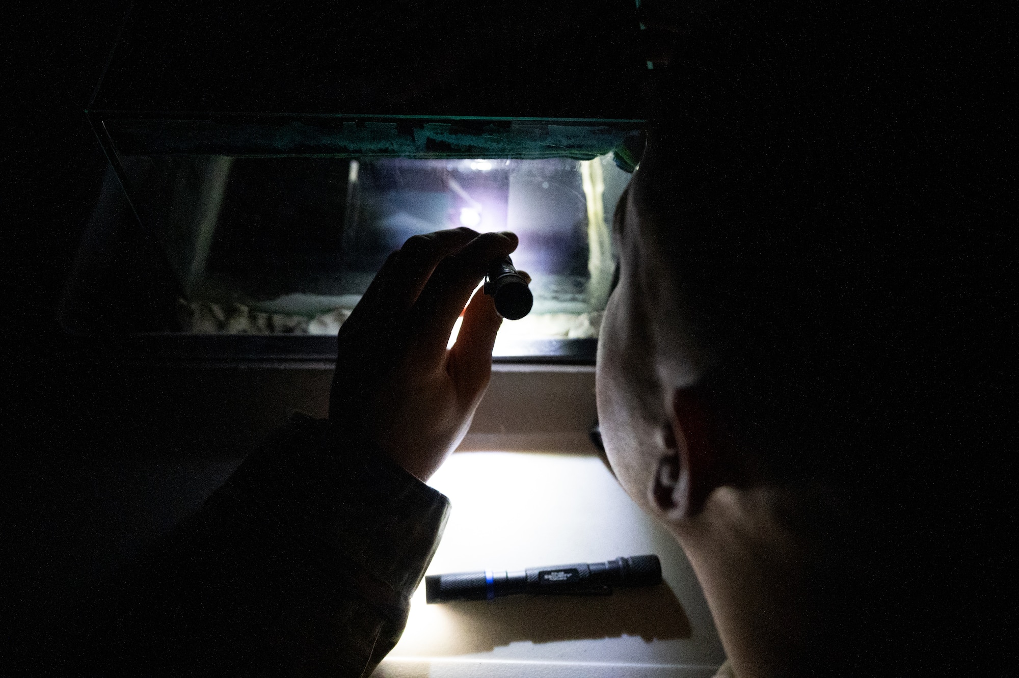 U.S. Senior Airman Brandon Wagner, 86th Operational Medical Readiness Squadron bioenvironmental engineering technician, shines a flashlight on radiation particles during a radiation cloud chamber demonstration at Ramstein Air Base, Germany, Nov. 24, 2025.