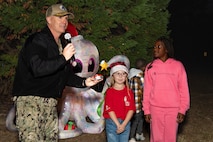 A photo of several people preparing to press a button.