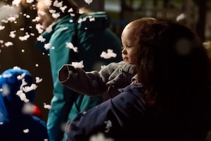A photo of a child looking at snow.