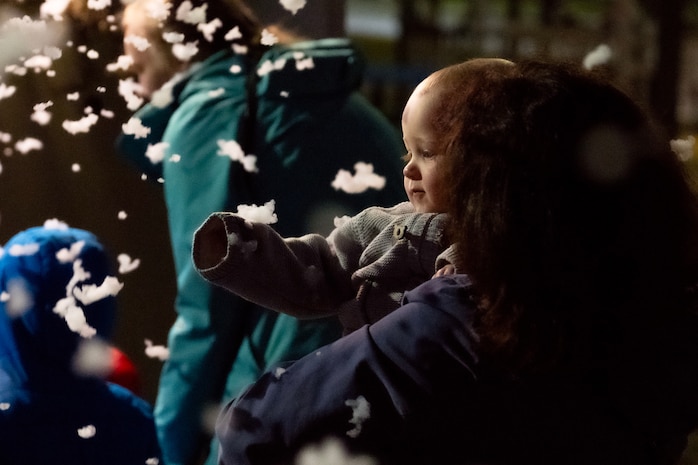 A photo of a child looking at snow.