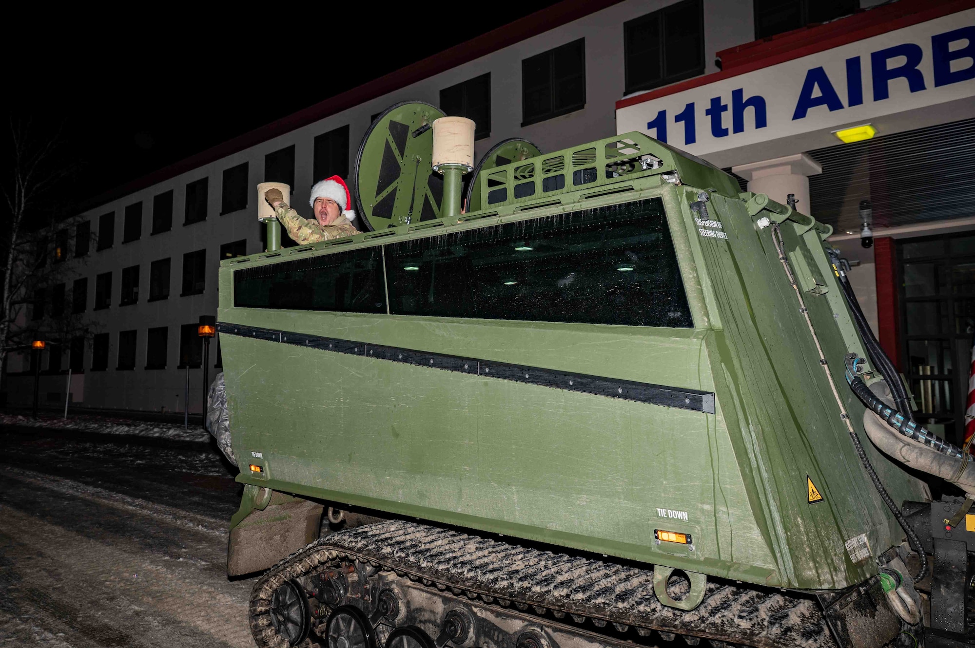 U.S. Army Col. Jimmy Howell, the Commander of the 2nd Airborne Brigade Combat Team, 11th Infantry Division, arrives in a Cold-Weather All-Terrain Vehicle (CATV) during the annual Tree Lighting Ceremony at Joint Base Elmendorf-Richardson, Alaska, Nov. 25, 2025. The 773d Force Support Squadron hosts the ceremony annually to promote community readiness and cohesion during the holiday season. (U.S. Air Force photo by Senior Airman Hunter Hites)