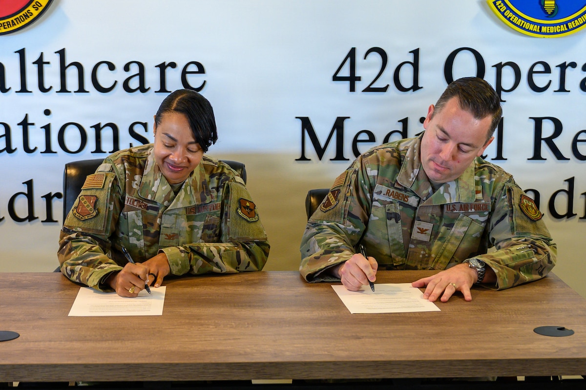 U.S. Air Force Col. Shamekia Toliver, 42d Air Base Wing commander and U.S. Air Force Col. Clayton Rabens, Maxwell Medical Group commander, sign a base support agreement strengthening cooperation between the 42d ABW and newly established Maxwell Medical Group under the 359th Medical Wing. A support agreement ensures clear responsibilities, reliable services and uninterrupted mission support between the installation and its newest tenant unit. (U.S. Air Force photo by Senior Airman Evan Lichtenhan)