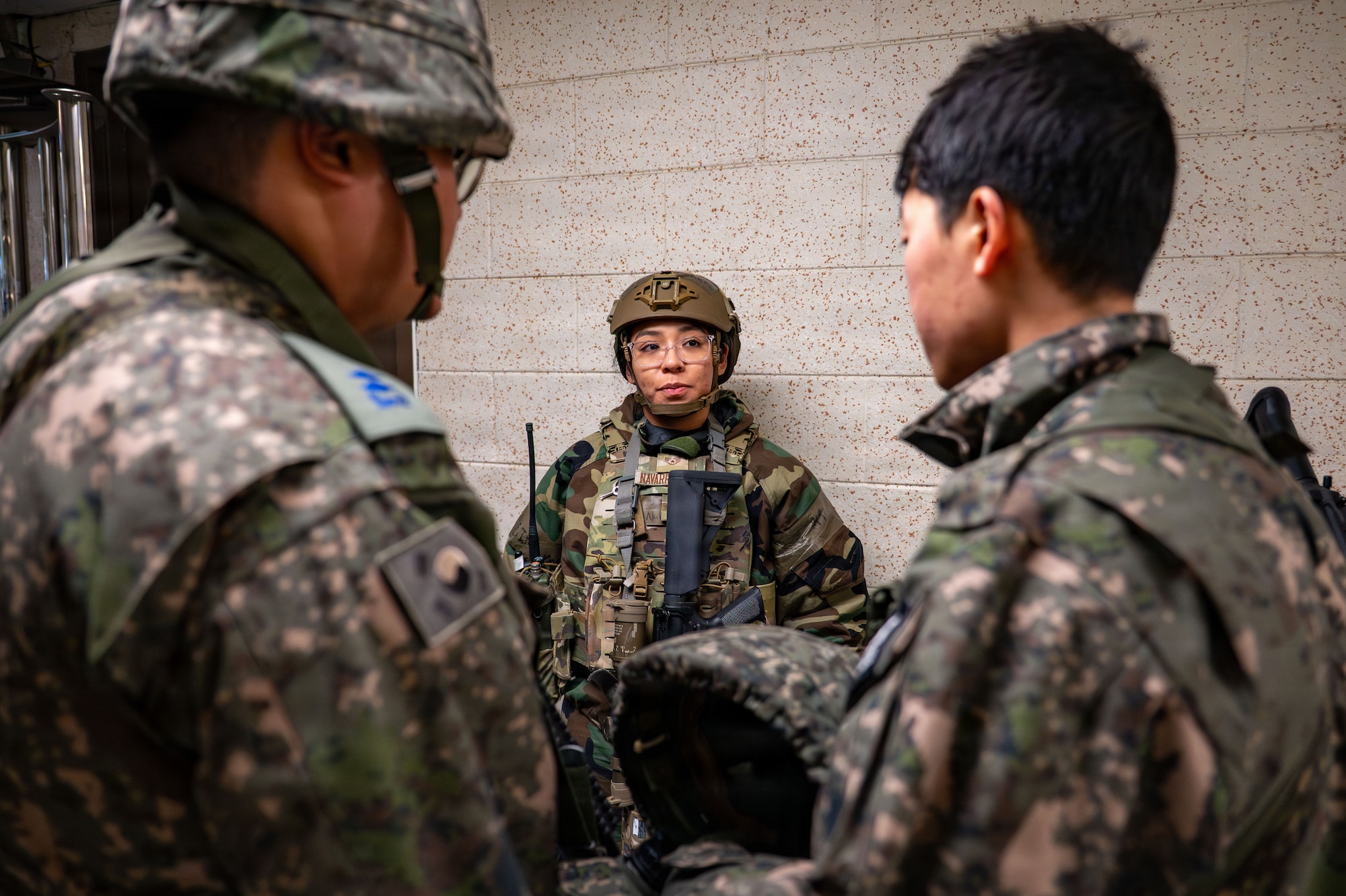 An U.S. Air Force security forces member tralks with 2 Republic of Korea air force MPs