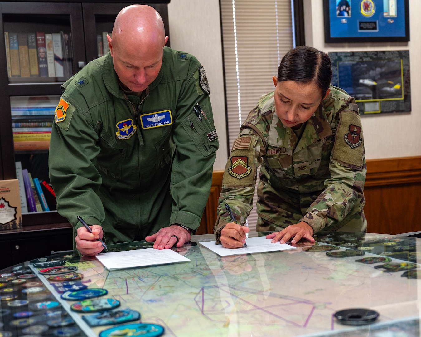U.S. Air Force Brig. Gen. David Berkland (left), 56th Fighter Wing commander, and Col. Adrianne Rosario (right), 56th Medical Group commander, sign a letter recognizing the implementation of the Air Force Medical Command, Nov. 21, 2025, at Luke Air Force Base, Arizona.