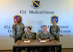 U.S. Air Force Chief Master Sgt. Demetrius Booth, 42d Air Base Wing command chief, U.S. Air Force Col. Shamekia Toliver, 42d ABW commander, U.S. Air Force Col. Clayton Rabens, Maxwell Medical Group commander and U.S. Air Force Chief Master Sgt. Gloria Winings, Maxwell Medical Group command chief, pose for a photo after the signing of a base support agreement between the 42d ABW and newly established Maxwell Medical Group at Maxwell Air Force Base, Alabama, Nov. 4, 2025. A support agreement ensures clear responsibilities, reliable services and uninterrupted mission support between the installation and its newest tenant unit (U.S. Air Force photo by Senior Airman Evan Lichtenhan)