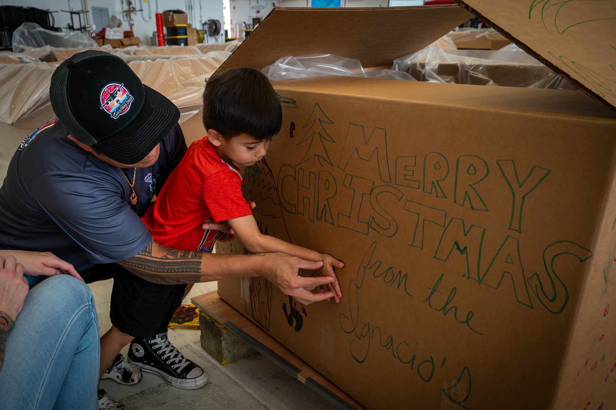 Service members and volunteers from multiple nations prepare and build airdrop bundles.
