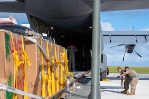 A military member loads boxes onto a C-130J aircraft.