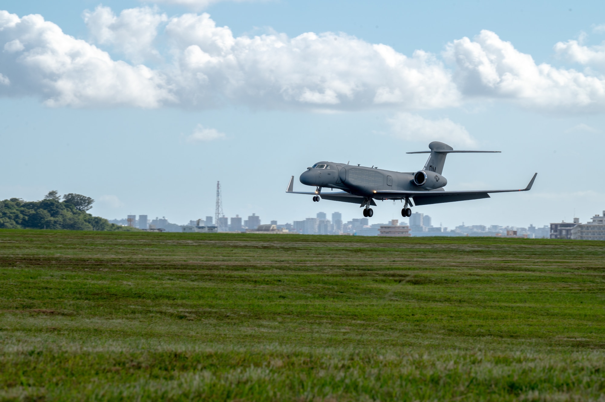 The left side of a light grey aircraft before it lands on the runway
