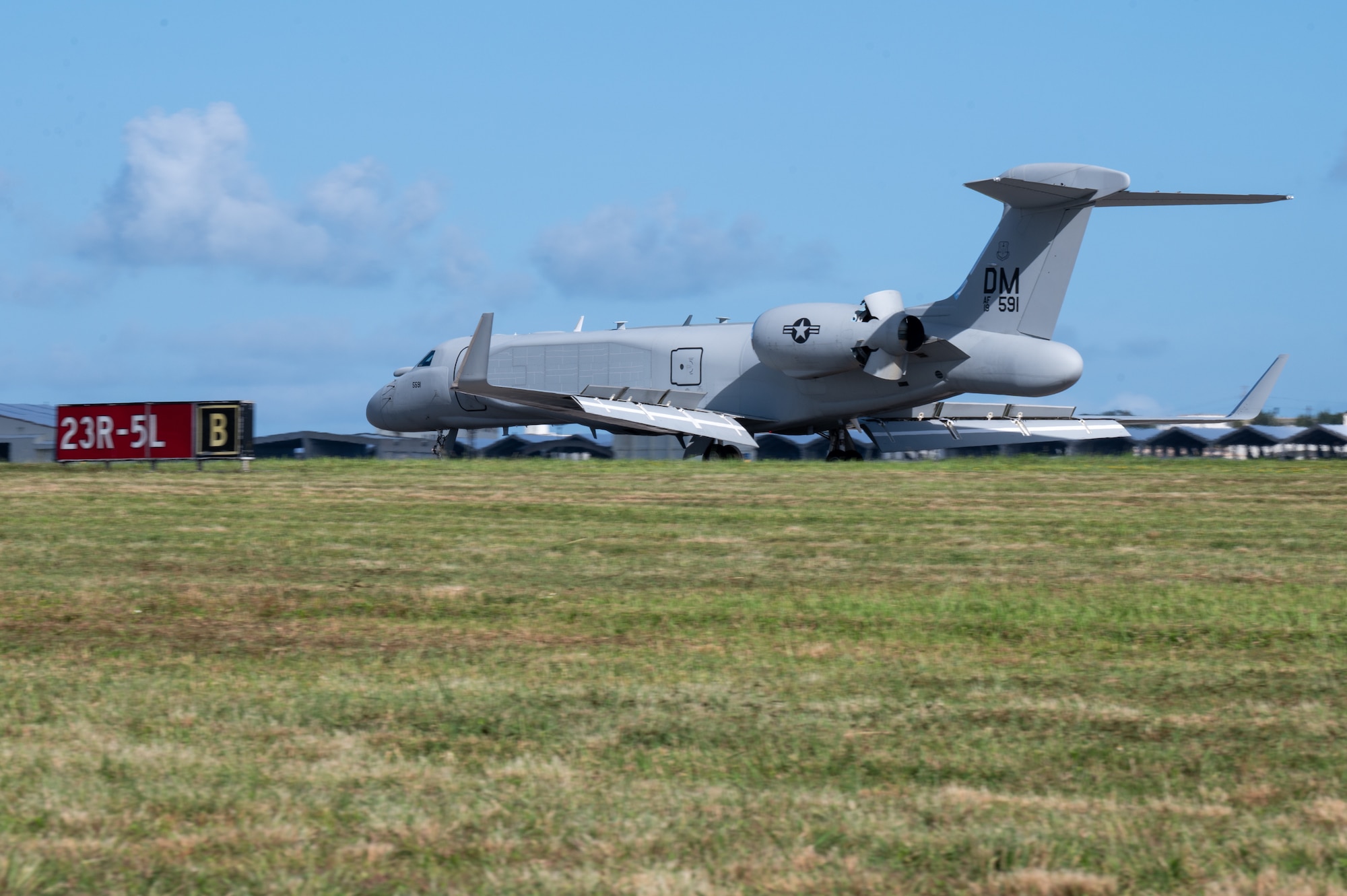 The left side of a white aircraft as it lands on the runway