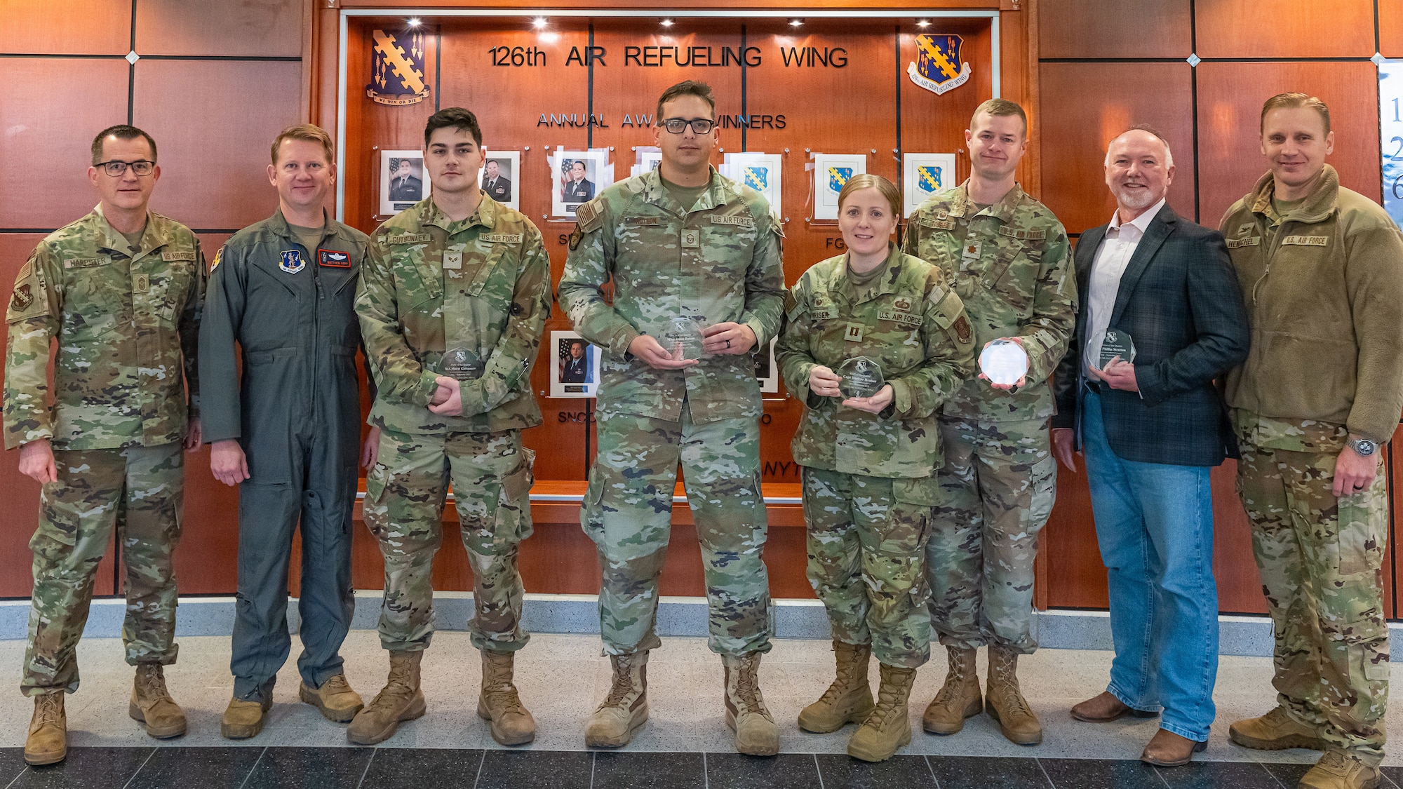 Eight airmen standing a row 5 glass awards