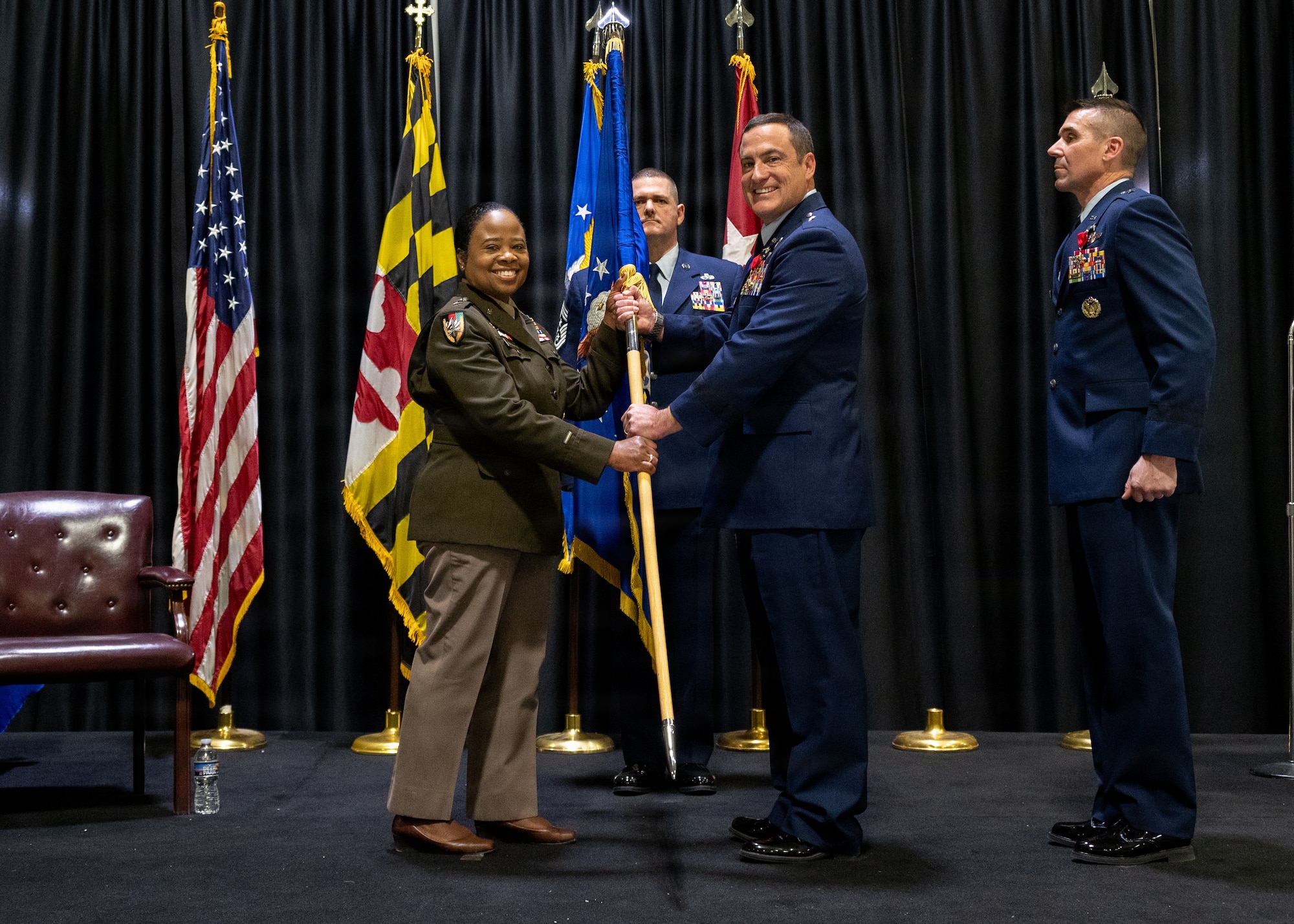 Maryland Army National Guard Maj. Gen. Janeen L. Birckhead, adjutant general of Maryland, receives the guidon from Maryland Air National Guard Brig. Gen. Drew E. Dougherty, commander of the Maryland Air National Guard, during the Maryland Air National Guard change of command ceremony in which Dougherty relinquished command to Maryland Air National Guard Brig. Gen. Richard Hunt, December 7, 2025, at Warfield Air National Guard Base at Martin State Airport, Middle River, Maryland. Dougherty is set to retire in January after 27 years with 10 years of active duty service and 17 years in the Air National Guard.  (U.S. Air National Guard photo by Airman 1st Class Sarah Hoover)
